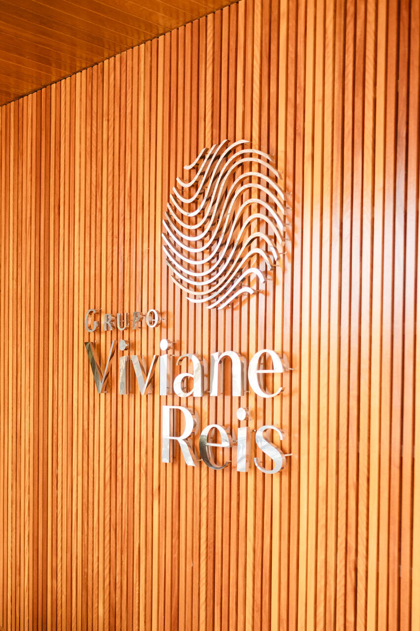 Recepção da clínica com o logo do Grupo Viviane Reis na parede